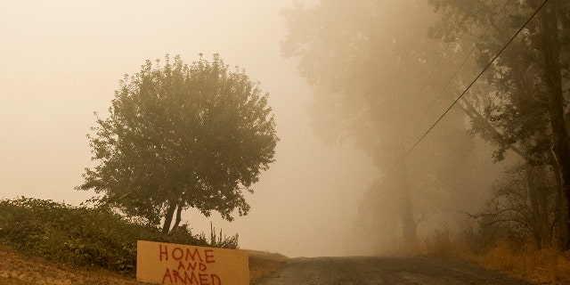 SUBLIMITY, OR - SEPTEMBER 13: A sign warns against looters as heavy smoke fills the air on September 13, 2020 in Sublimity, Oregon. Multiple wildfires grew by hundreds of thousands of acres this week forcing evacuations and road closures. (Photo by Nathan Howard/Getty Images)