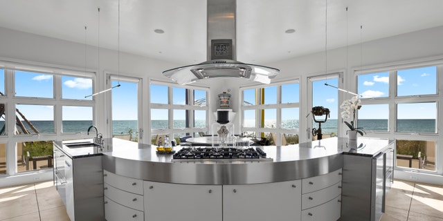 Inside, the chef's kitchen features floor-to-ceiling windows.