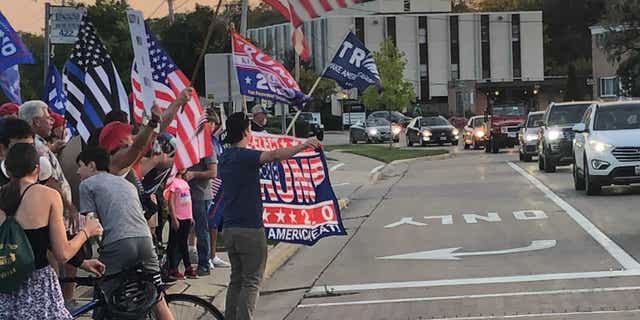 A pro-Trump group gathers Friday after an anti-Trump display was unveiled in Northbrook, Ill.