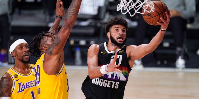 The Denver Nuggets' Jamal Murray (27) drives past the Los Angeles Lakers' Dwight Howard (39) during the second half of an NBA Western Conference final playoff basketball game Thursday, Sept. 24, 2020, in Lake Buena Vista, Fla. (AP Photo/Mark J. Terrill)