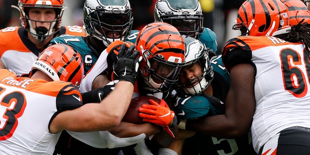 Cincinnati Bengals' Joe Mixon (28) is tackled by Philadelphia Eagles' Fletcher Cox (91) and T.J. Edwards (57) during the second half of an NFL football game, Sunday, Sept. 27, 2020, in Philadelphia. (AP Photo/Laurence Kesterson)