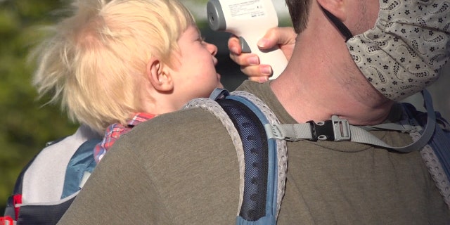 A temperature check outside an early childhood program at Our Lady of Perpetual Help Mission Grammar School in Boston. Elementary school classes start on Sept. 15.
