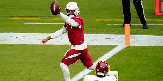 Arizona Cardinals quarterback Kyler Murray (1) scores a touchdown as Washington Football Team strong safety Landon Collins (26) looks on during the first half of an NFL football game, Sunday, Sept. 20, 2020, in Glendale, Ariz. (AP Photo/Ross D. Franklin)