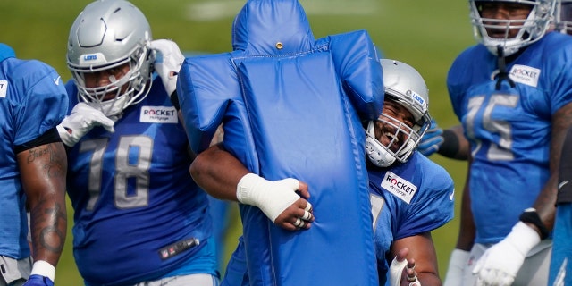Detroit Lions defensive tackle John Penisini hits a tackling dummy during drills at the Lions NFL football practice, Tuesday, Sept. 1, 2020, in Allen Park, Mich. (AP Photo/Carlos Osorio)