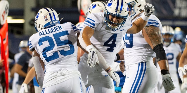 BYU's Lopini Katoa (4) and Tyler Allgeier (25) celebrate during the first half of an NCAA college football game against Navy, Monday, Sept. 7, 2020, in Annapolis, Md. (AP Photo/Tommy Gilligan)