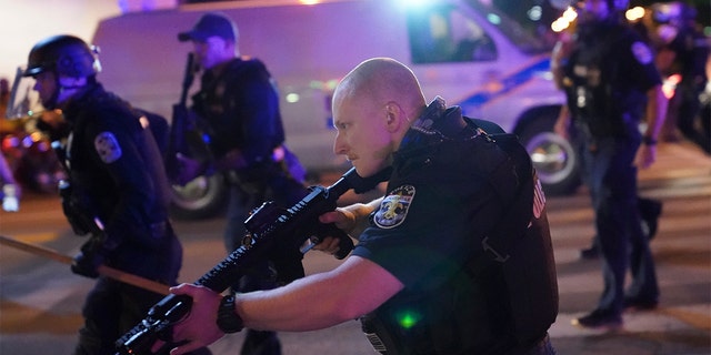 Police move after a Louisville Police officer was shot, Sept. 23, in Louisville, Ky. (Associated Press)