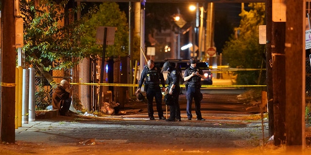 Police survey an area after a police officer was shot, Wednesday, Sept. 23, 2020, in Louisville, Ky. (AP Photo/John Minchillo)