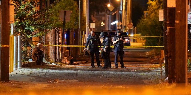 Police survey an area after a police officer was shot, Wednesday, Sept. 23, 2020, in Louisville, Ky. (AP Photo/John Minchillo)