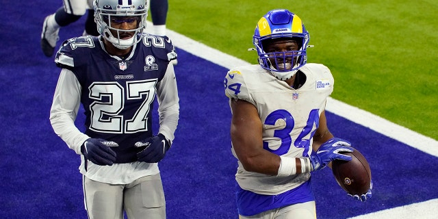 Los Angeles Rams running back Malcolm Brown (34) smiles after scoring a rushing touchdown next to Dallas Cowboys defensive back Trevon Diggs (27) during the second half of an NFL football game Sunday, Sept. 13, 2020, in Inglewood, Calif. (AP Photo/Ashley Landis)
