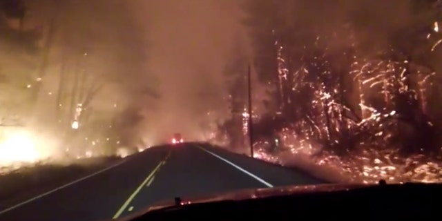 Flames can be seen Oregon Highway 18 in Lincoln County on Sept. 9, 2020 are residents evacuate from wildfires in the area.