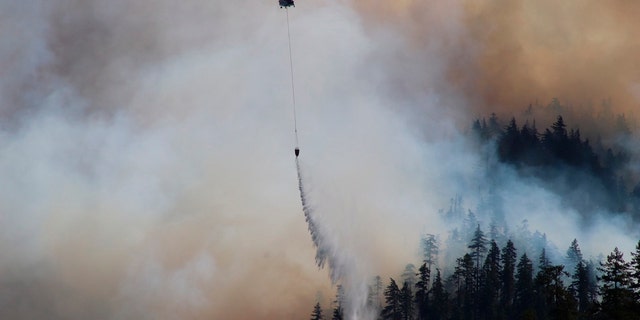 In this Sept. 3, 2020, photo provided by the Opal Creek Ancient Forest Center, fire retardant is dropped at Jawbone Flats in the Opal Creek Wilderness in Oregon.
