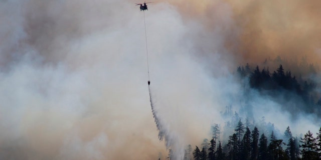 In this Sept. 3, 2020, photo provided by the Opal Creek Ancient Forest Center, fire retardant is dropped at Jawbone Flats in the Opal Creek Wilderness in Oregon.