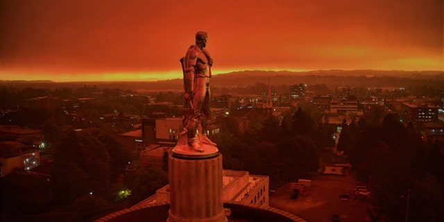 This drone photo provided by Michael Mann shows the Oregon Capitol building, with its "Oregon Pioneer" bronze sculpture atop the dome, with skies filled with smoke and ash from wildfires as a backdrop in Salem, Ore., on Sept. 8, 2020.