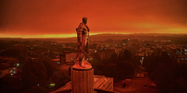 This drone photo provided by Michael Mann shows the Oregon Capitol building, with its "Oregon Pioneer" bronze sculpture atop the dome, with skies filled with smoke and ash from wildfires as a backdrop in Salem, Ore., on Sept. 8, 2020.