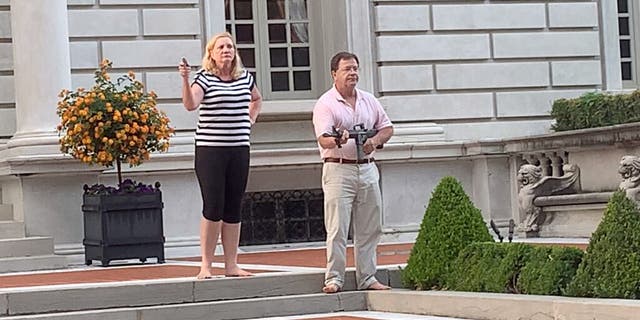 A couple draws their firearms on protestors as they enter their neighborhood during a protest against St. Louis Mayor Lyda Krewson in June. Nine Black Lives Matter protesters were issued citations for trespassing in connection with the incident but prosecutors announced Tuesday that the charges were refused. (DANIEL SHULAR/via REUTERS)