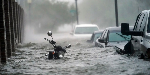 Flood waters move on the street, Wednesday, Sept. 16, 2020, in Pensacola, Fla.