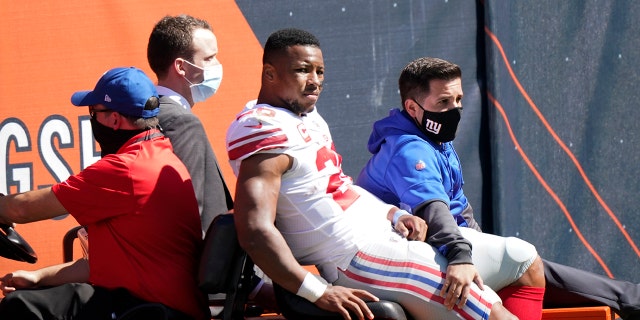 New York Giants running back Saquon Barkley (26) is carted to the locker room after being injured during the first half of an NFL football game against the Chicago Bears in Chicago, Sunday, Sept. 20, 2020. (AP Photo/Nam Y. Huh)