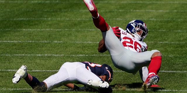 New York Giants running back Saquon Barkley (26) is brought down by Chicago Bears cornerback Kyle Fuller (23) during the first half of an NFL football game in Chicago, Sunday, Sept. 20, 2020. (AP Photo/Charles Rex Arbogast)
