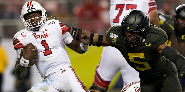 In this Dec. 6, 2018, file photo, Utah quarterback Tyler Huntley (1) is sacked by Oregon defensive end Kayvon Thibodeaux (5) during the second half of an NCAA college football game for the Pac-12 Conference championship in Santa Clara, California.