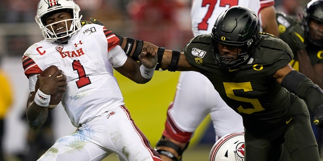 In this Dec. 6, 2018, file photo, Utah quarterback Tyler Huntley (1) is sacked by Oregon defensive end Kayvon Thibodeaux (5) during the second half of an NCAA college football game for the Pac-12 Conference championship in Santa Clara, California.