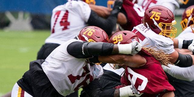 Washington offensive tackle Morgan Moses (76) blocks defensive end Chase Young (99) during an NFL football practice at FedEx Field, Monday, Aug. 31, 2020, in Washington. (AP Photo/Alex Brandon)