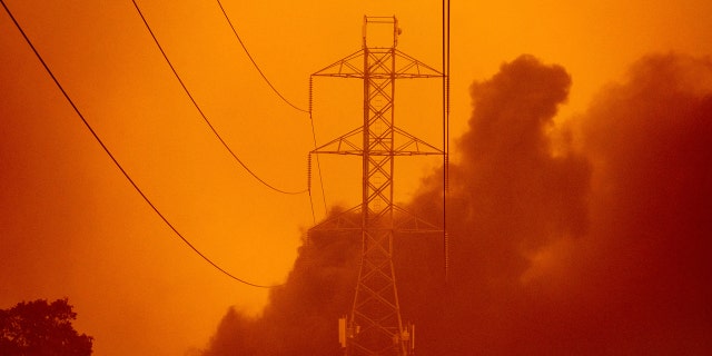 Smoke wafts past power lines as the Glass Fire burns in Santa Rosa, Calif., Monday, Sept. 28, 2020.