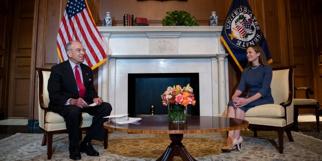 Judge Amy Coney Barrett, President Donald Trump's nominee to the Supreme Court, right, meets with Sen. Chuck Grassley, R-Iowa, at the Capitol, Tuesday, Sept. 29, 2020 in Washington. (Caroline Brehman/Pool via AP)