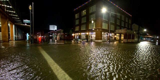 Water rises from the storm surge of Tropical Storm Beta in The Strand as the storm moves toward landfall late Monday, Sept. 21, 2020, in Galveston, Texas.