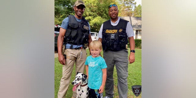 Deputies posed with the dalmatian and its young owner after reuniting the dog with its rightful family on Saturday.