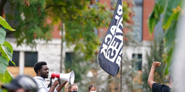 A man speaks to Black Lives Matter protesters, Friday, Sept. 25, 2020, in Louisville. (AP Photo/Darron Cummings)