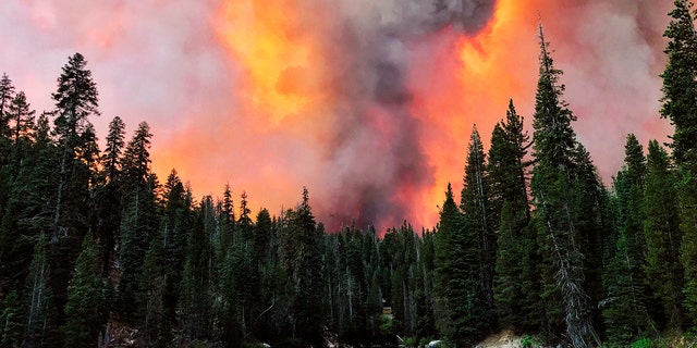 Smoke from the Creek Fire billows beyond a ridge as seen from Huntington Lake on Saturday, Sept. 5, 2020, at Huntington Lake, Calif.