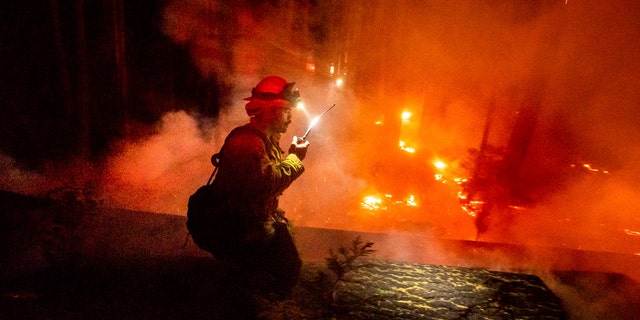 A firefighter battles the Creek Fire in the Shaver Lake community of Fresno County, Calif., on Monday, Sept. 7, 2020.