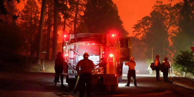 Firefighters stage near a Southern California Edison power station to protect it from the advancing Creek Fire, Sunday, Sept. 6, 2020, in Big Creek, Calif.