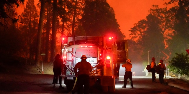 Firefighters stage near a Southern California Edison power station to protect it from the advancing Creek Fire, Sunday, Sept. 6, 2020, in Big Creek, Calif.