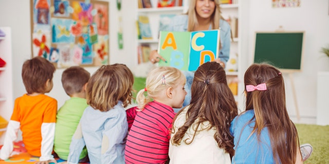 Teacher with a group of preschool children in a nursery.