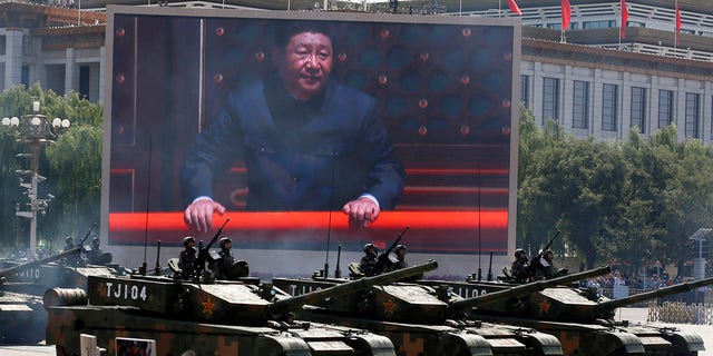 In this Thursday, Sept. 3, 2015 file photo, Chinese President Xi Jinping is displayed on a screen as Type 99A2 Chinese battle tanks take part in a parade commemorating the 70th anniversary of Japan's surrender during World War II held in front of Tiananmen Gate in Beijing. (AP Photo/Ng Han Guan, File)