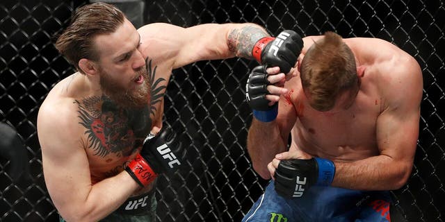 Conor McGregor hits Donald "Cowboy" Cerrone during a UFC 246 welterweight mixed martial arts bout Saturday, Jan. 18, 2020, in Las Vegas. (AP Photo/John Locher)