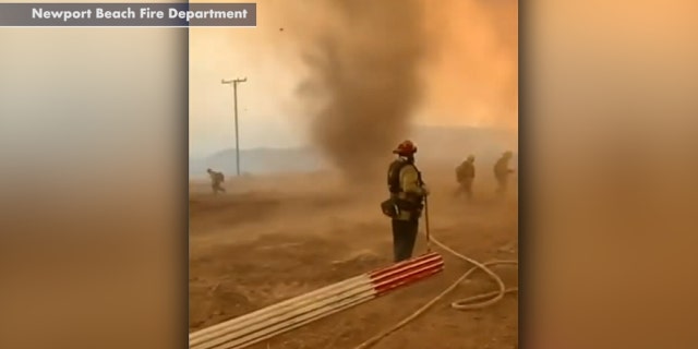 A smoke dust devil rages as firefighters battle the El Dorado wildfire in California.