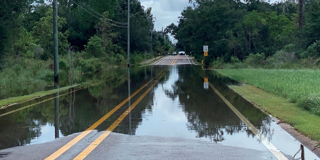 Waters begin to flood Davis Avenue from the Davis Avenue River in Pass Christian, Miss., Monday, Sept. 14, 2020, as rains associated with incoming Hurricane Sally begin to overflow its banks.