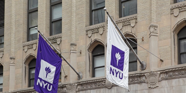 Purple and white NYU flags hang from a New York University building on West 4th Street in Manhattan. 