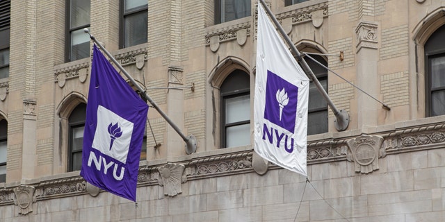 Purple and white NYU flags hang from a New York University building on West 4th Street in Manhattan. 