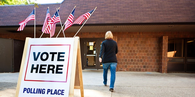 A woman voter enters a polling place.