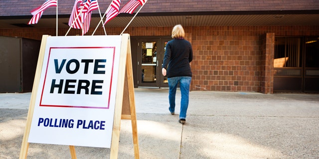 A woman voter enters a polling place.