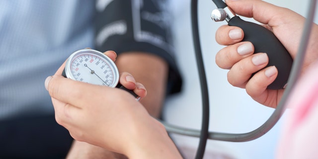 A nurse measures a patient's blood pressure. 