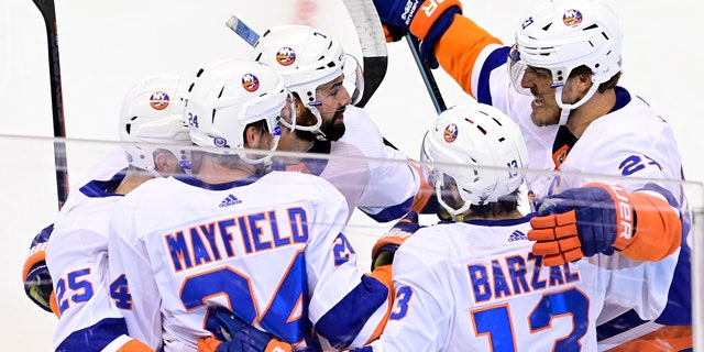New York Islanders defenseman Scott Mayfield (24) celebrates his goal against the Philadelphia Flyers with teammates during first-period NHL Stanley Cup Eastern Conference playoff hockey game action in Toronto, Saturday, Sept. 5, 2020. (Frank Gunn/The Canadian Press via AP)