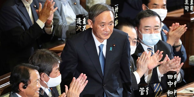 Yoshihide Suga is applauded after being elected as Japan's prime minister at the parliament's lower house in Tokyo, Wednesday, Sept. 16, 2020. Suga was formally elected Wednesday as new prime minister in a parliamentary vote, replacing Shinzo Abe. (AP Photo/Koji Sasahara)