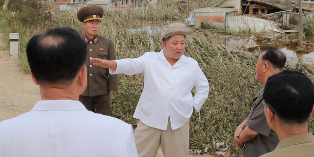 In this Saturday, Sept. 5, 2020, photo provided by the North Korean government, North Korea leader Kim Jong Un talks to officials as he visits a damaged area in the South Hamgyong province.