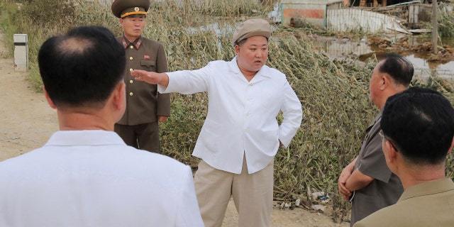 In this Saturday, Sept. 5, 2020, photo provided by the North Korean government, North Korea leader Kim Jong Un talks to officials as he visits a damaged area in the South Hamgyong province.