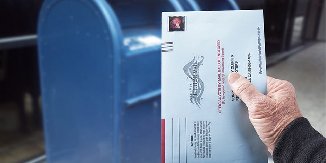 Gualala, CA, July 4, 2020 — Person mailing United States absentee ballot for voting in an election by mail.