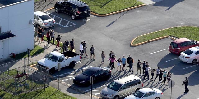 Students are evacuated by police from Marjory Stoneman Douglas High School in Parkland, Fla., during a February 2018 mass shooting that killed 17 students and staff. On Thursday, the state Supreme Court capped compensation at $300,000 for families and victims who filed lawsuits against the Broward County School Board over the incident. 